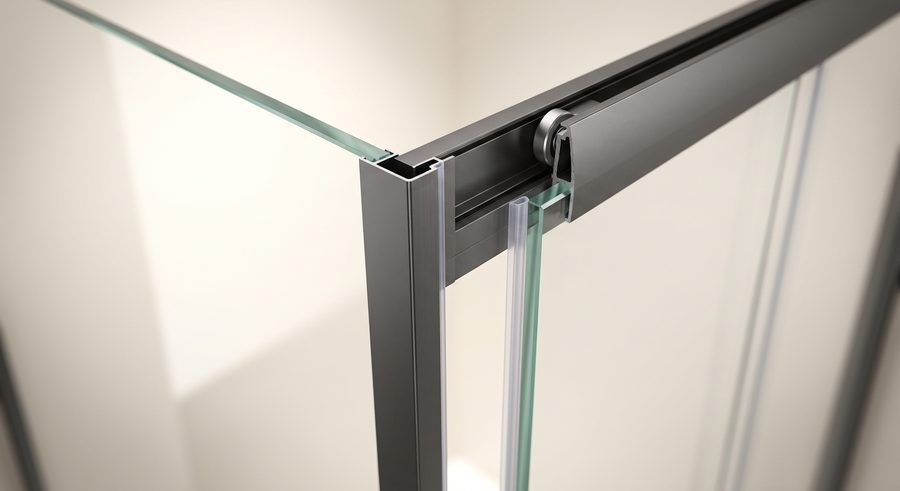 Detalle de cancel de baño: cristal templado en perfil de aluminio antracita con rodamiento sobre riel